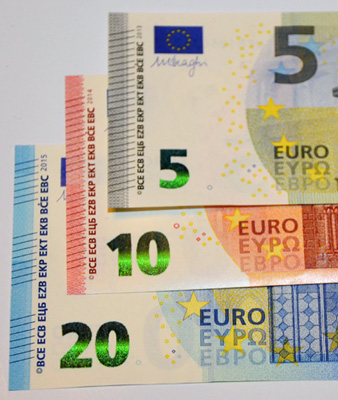 Eine 20 €, 10 € und 5 €-Banknote liegen übereinander, um besser die Reihe der fühlbaren  kurzen  Linien vergleichen zu können